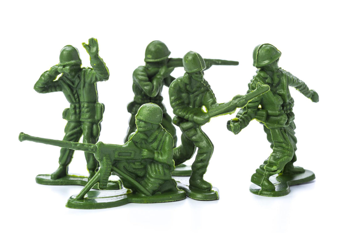 Green plastic army men in a collection standing in different directions.